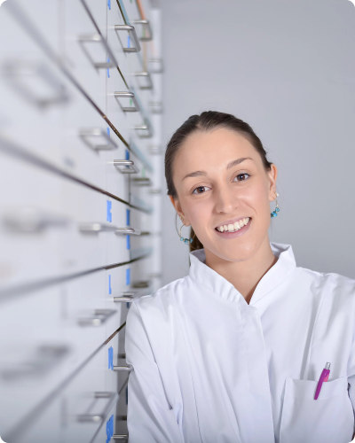 Chica apoyada en una estantería de farmacia