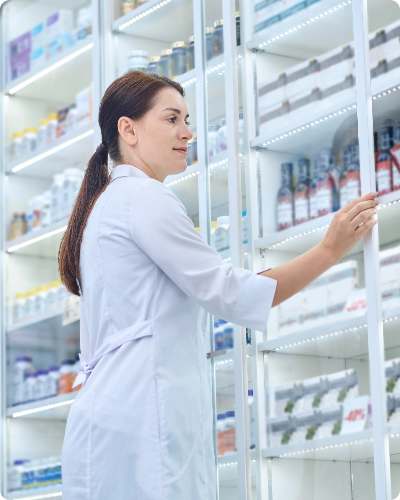 Chica reponiendo las estanterías de productos farmaceuticos